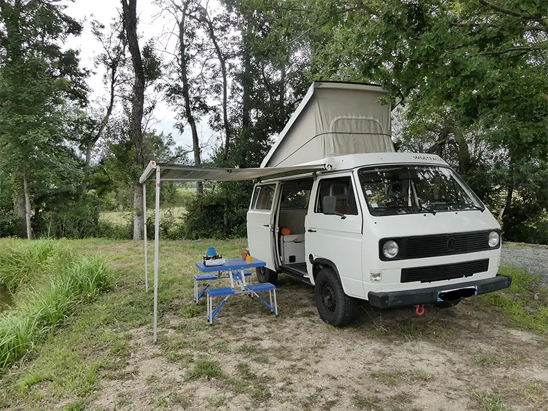 petite-img-tao-4 Image de "Tao" en bivouac en pleine nature en Rhône Alpes. La table et les chaises sont sorties ainsi que le store latérale. Ce van est en location chez Ryôko - spécialiste de la location de vans pour slow travel dans la Loire.