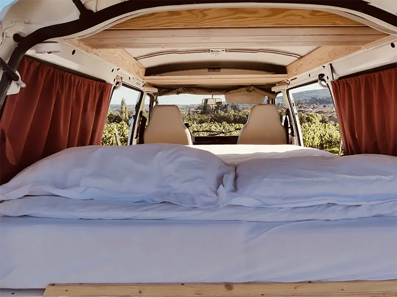 img-gaia-6 Image de l'espace intérieur de couchage de "Gaïa" en bivouac au bord d'une vigne en Rhône Alpes. Ce van est en location chez Ryôko - spécialiste de la location de vans pour slow travel dans la Loire.