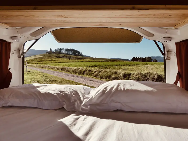 img-gaia-7 Image de l'espace intérieur de couchage de "Gaïa" en bivouac en pleine nature en Rhône Alpes. Ce van est en location chez Ryôko - spécialiste de la location de vans pour slow travel dans la Loire.